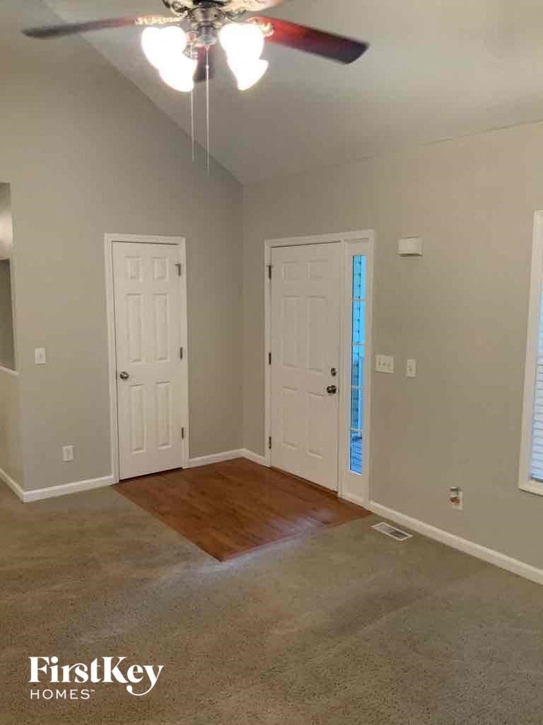 A room with a ceiling fan and two doors.