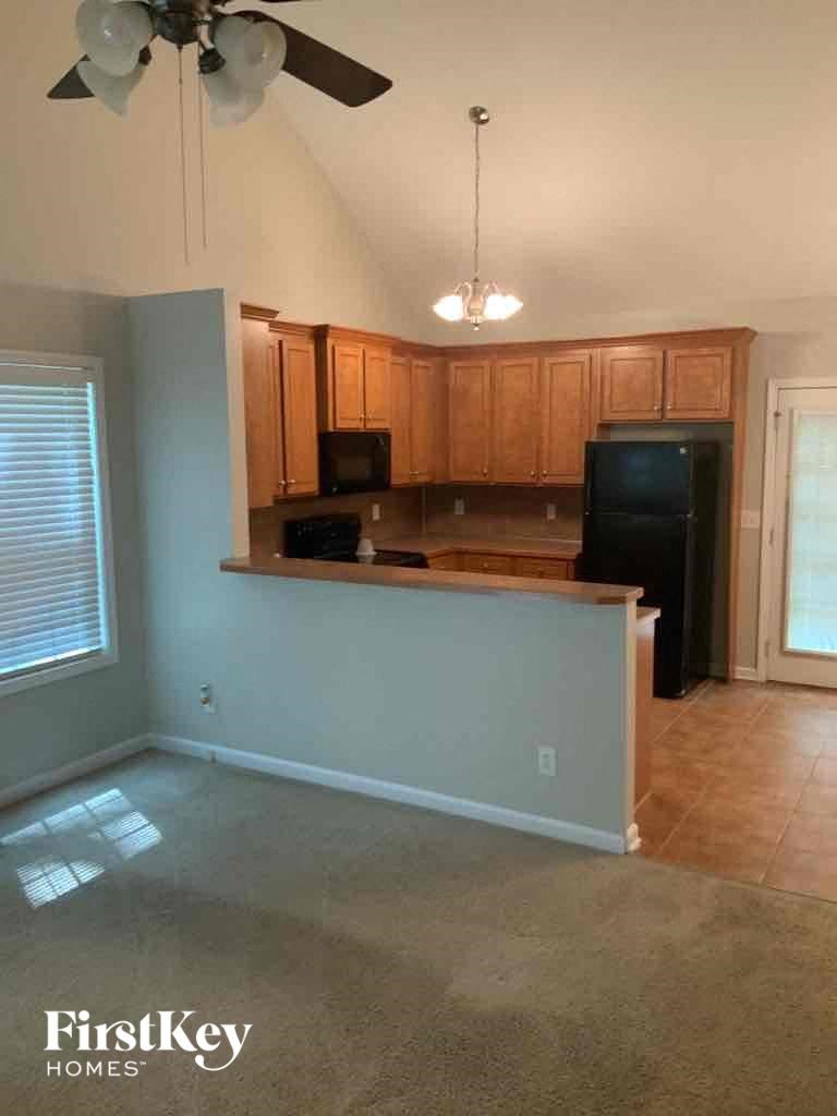 A kitchen with a fan and a fridge.