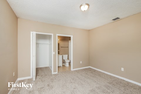 a living room with a carpeted floor and a door to a bathroom
