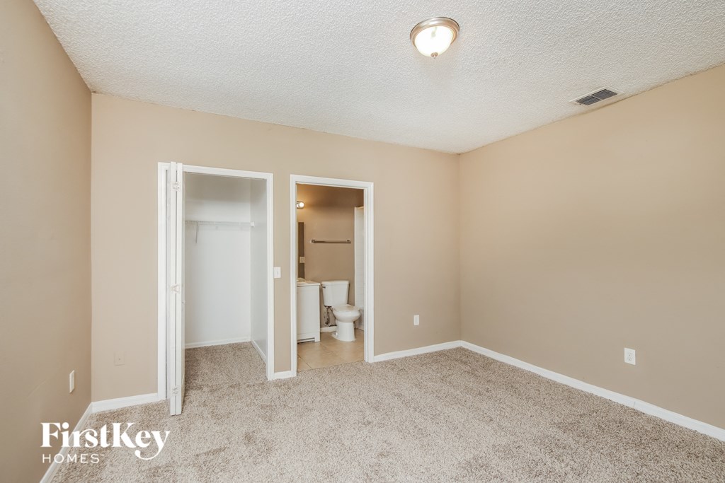 a living room with a carpeted floor and a door to a bathroom