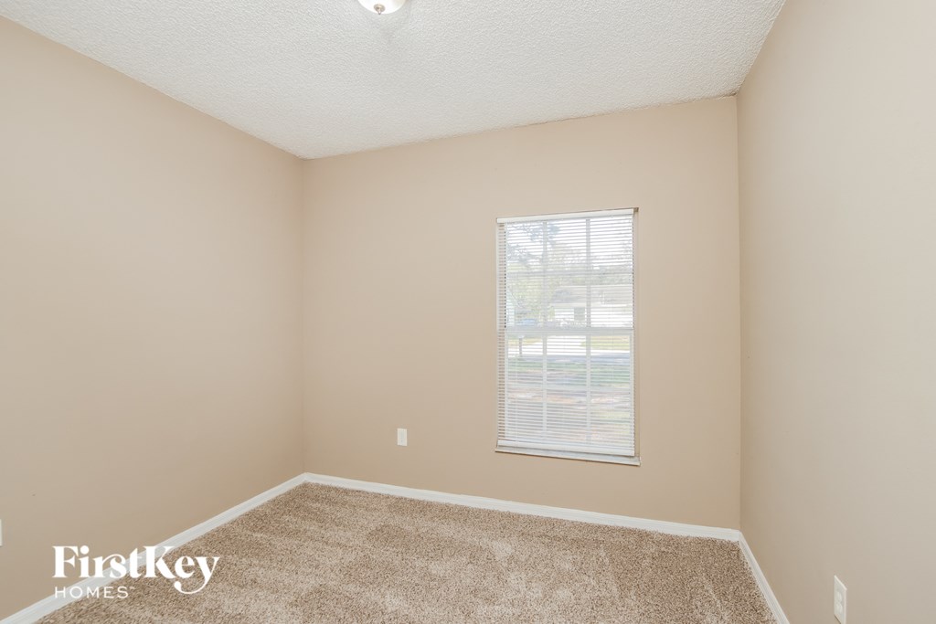 a spacious room with carpet and a window