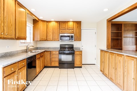 A kitchen with wooden cabinets and a stove top oven.