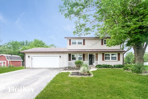 A two-story house with a garage and a driveway.