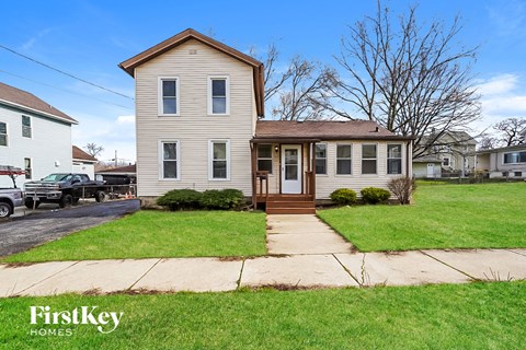 a white house with a wooden front porch and a sidewalk