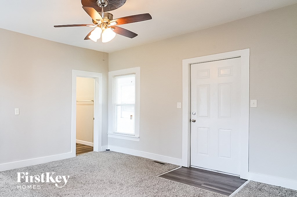 a bedroom with a ceiling fan and a white door