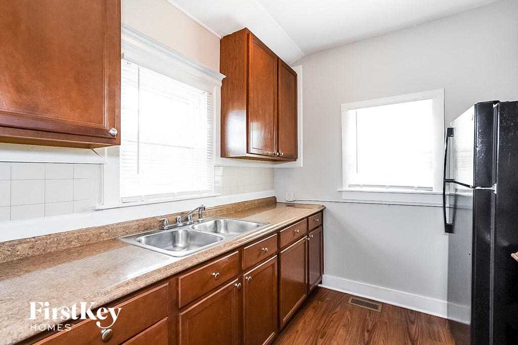 a kitchen with wooden cabinets and a sink and a refrigerator