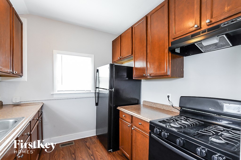 a kitchen with wooden cabinets and a black stove and refrigerator