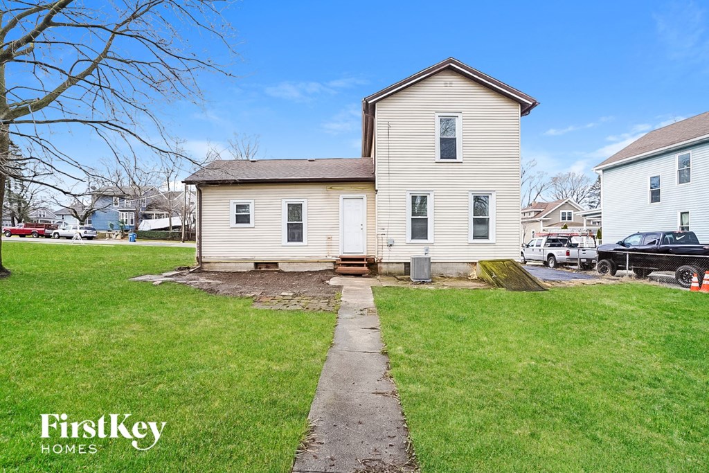 a white house with a lawn and a sidewalk