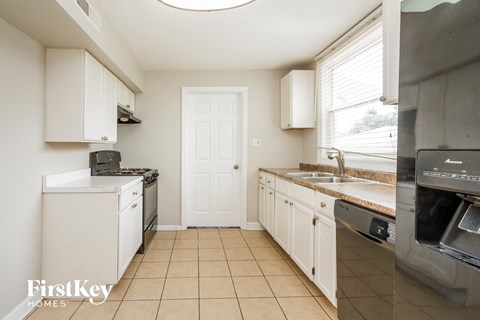 a kitchen with white cabinets and a sink and an oven
