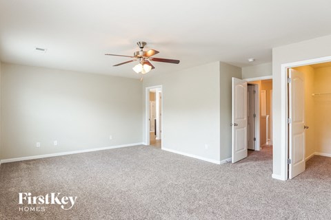 a living room with carpet and a ceiling fan