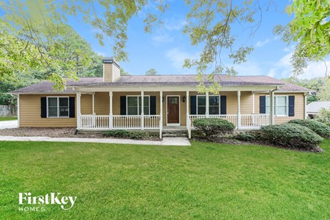 a yellow house with a lawn and a porch