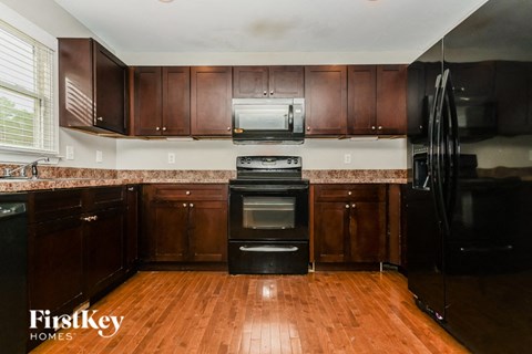 a kitchen with dark wood cabinets and black appliances
