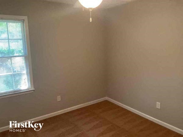 the corner of a room with a window and wood floor