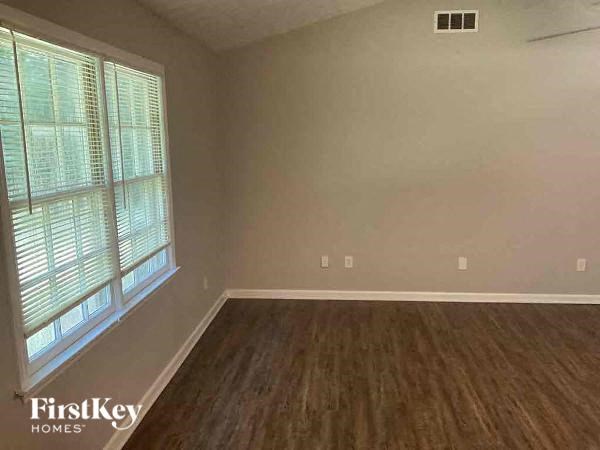 an empty living room with wood floors and a large window