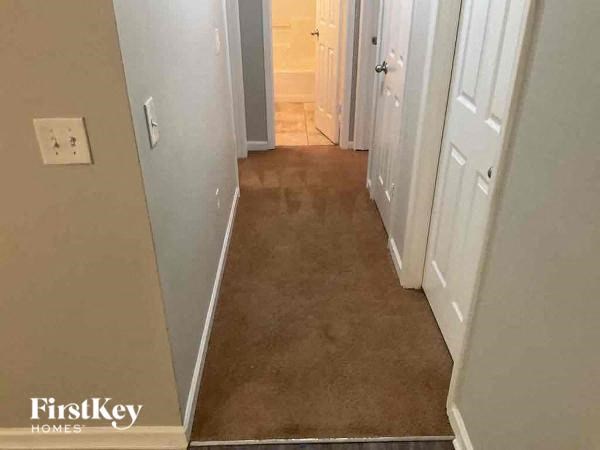 a hallway with a carpeted floor and a white door