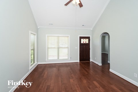 A room with wooden floors and a ceiling fan.