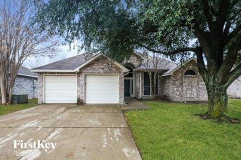 a white garage door in front of a brick house