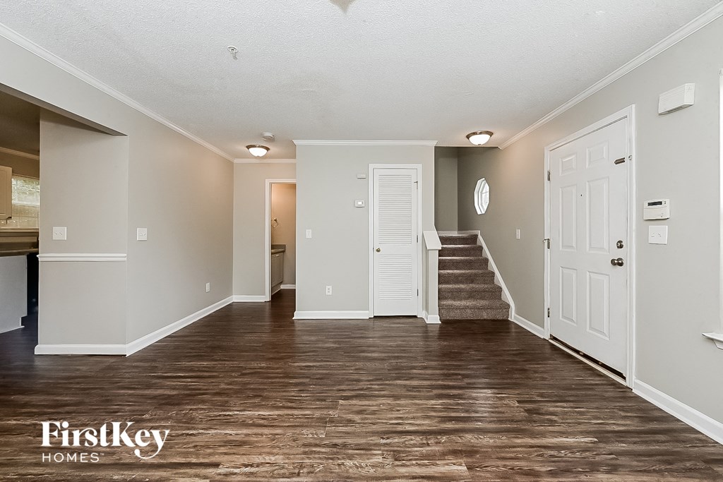 A spacious room with wooden floors and white walls.