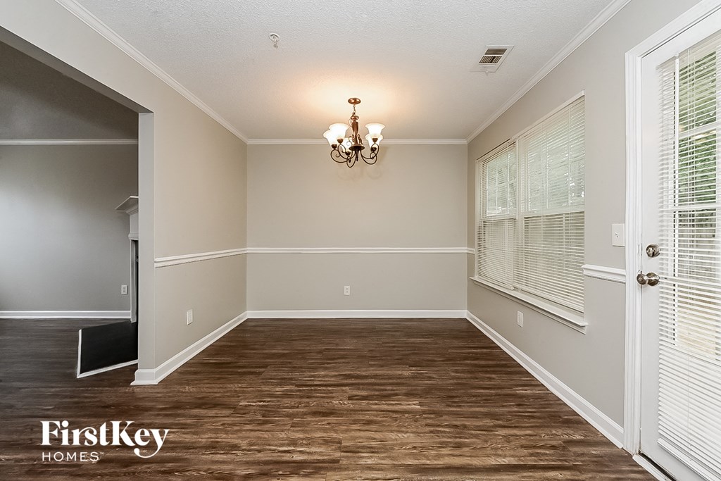 A room with wooden floors and a chandelier hanging from the ceiling.