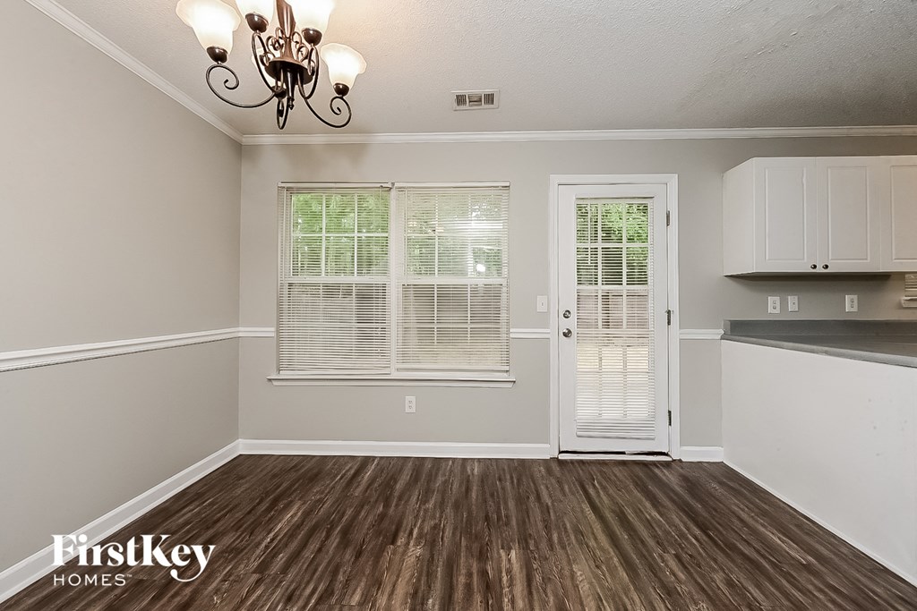 A room with a wooden floor and a chandelier.