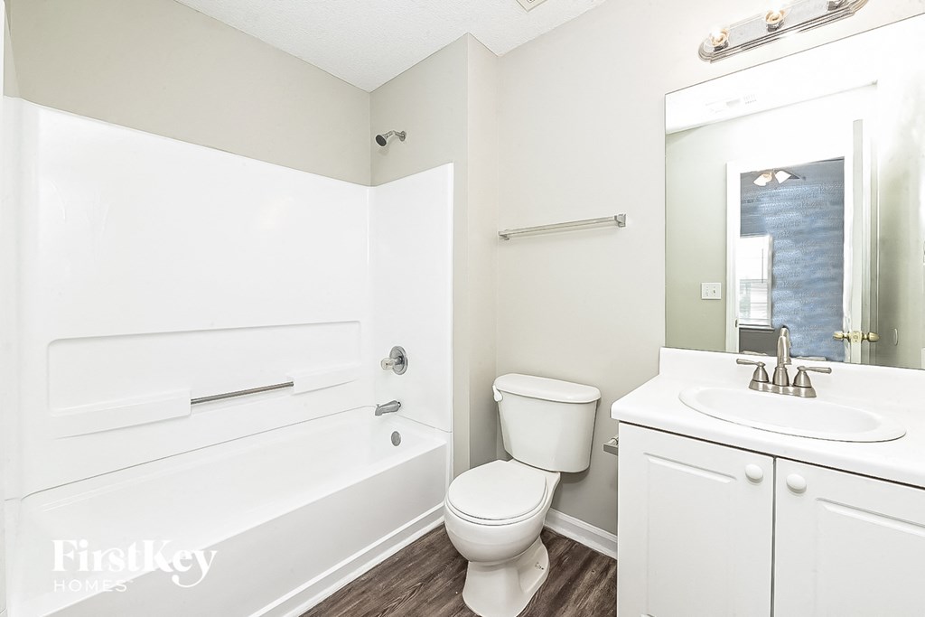 A white bathroom with a toilet, sink, and bathtub.