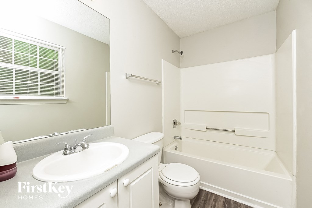 A white bathroom with a toilet, sink, and bathtub.