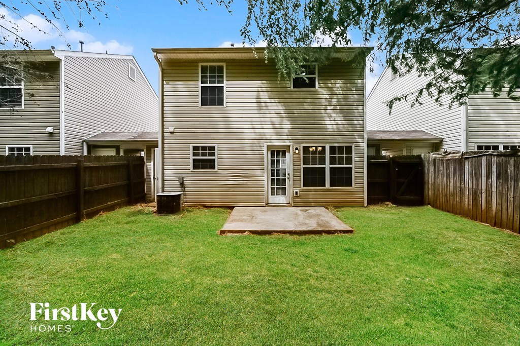 A house with a brown fence and a green lawn.