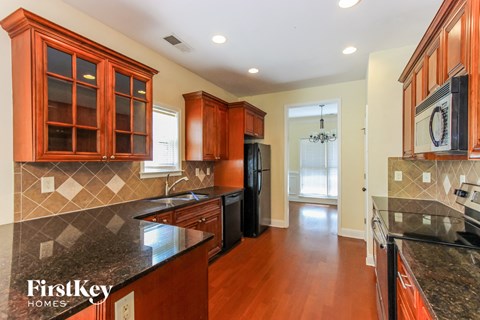 a kitchen with black granite counter tops and wooden cabinets