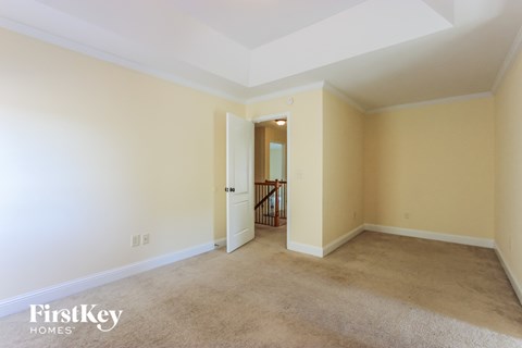 a living room with carpet and a door to a hallway