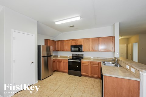 A kitchen with wooden cabinets and black appliances.