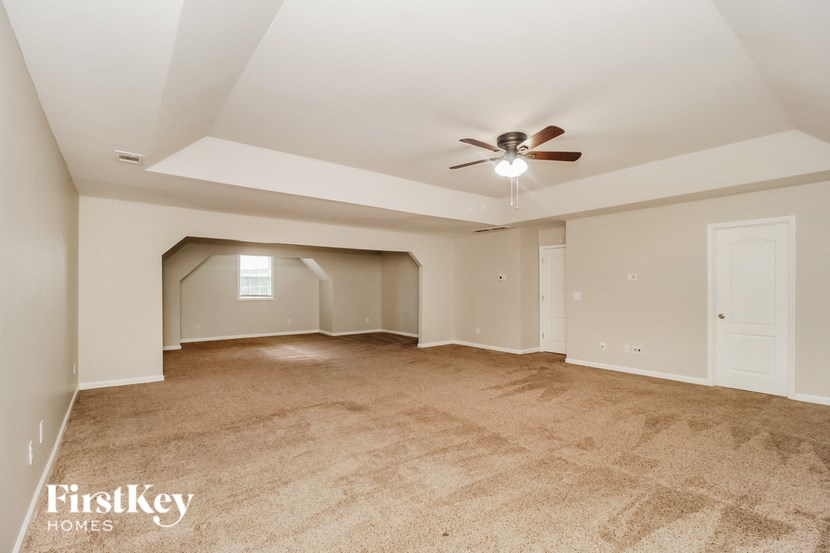 a living room with a ceiling fan and a carpeted floor