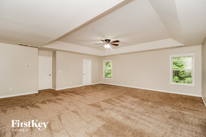 a living room with carpet and a ceiling fan