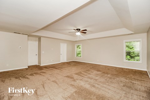 a living room with carpet and a ceiling fan