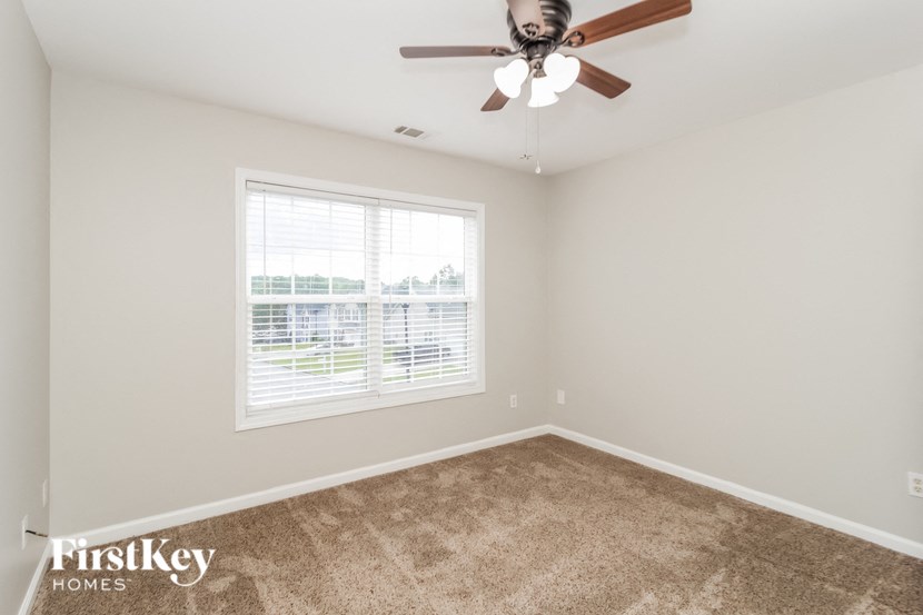 a bedroom with a ceiling fan and a window