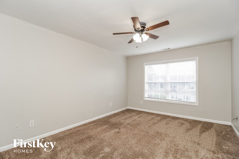a bedroom with a ceiling fan and a window