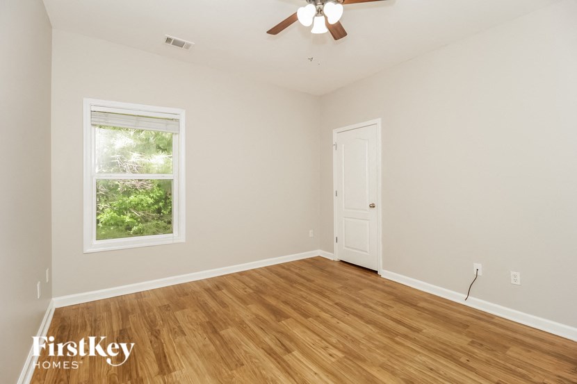 a living room with a wooden floor and a ceiling fan