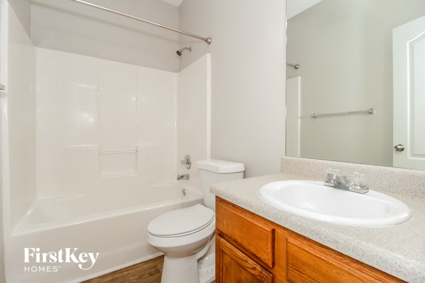 a white bathroom with a sink toilet and shower
