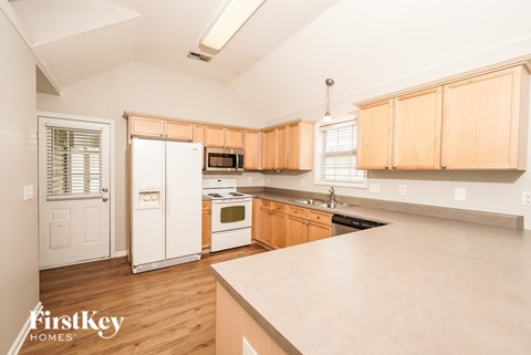 A kitchen with wooden cabinets and a white fridge.
