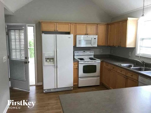 A kitchen with wooden cabinets and a white fridge.