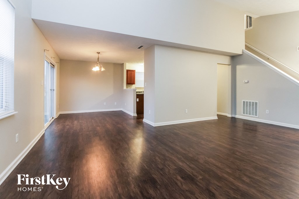 an empty living room with wood flooring and white walls