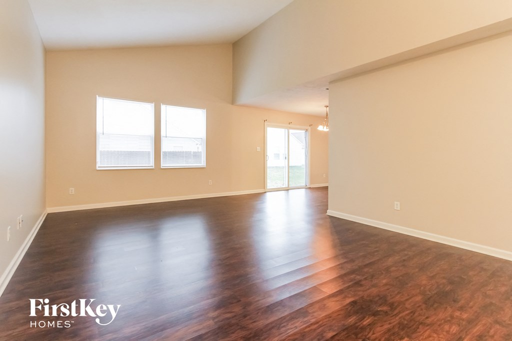 the living room and dining room of an empty house with wood floors