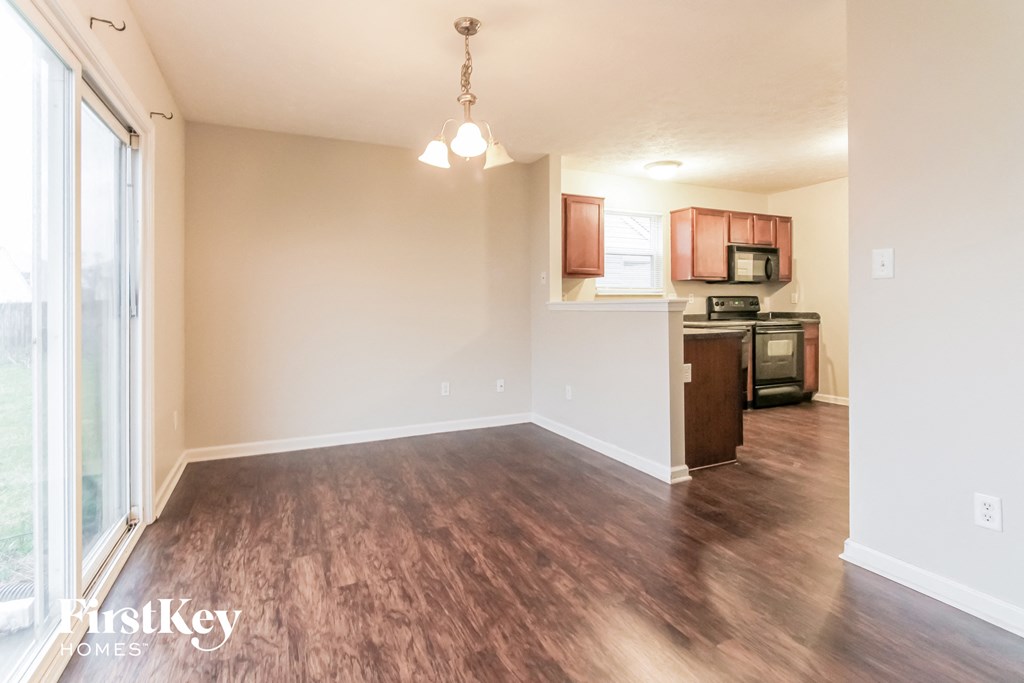 a living room and kitchen with wood flooring and a window
