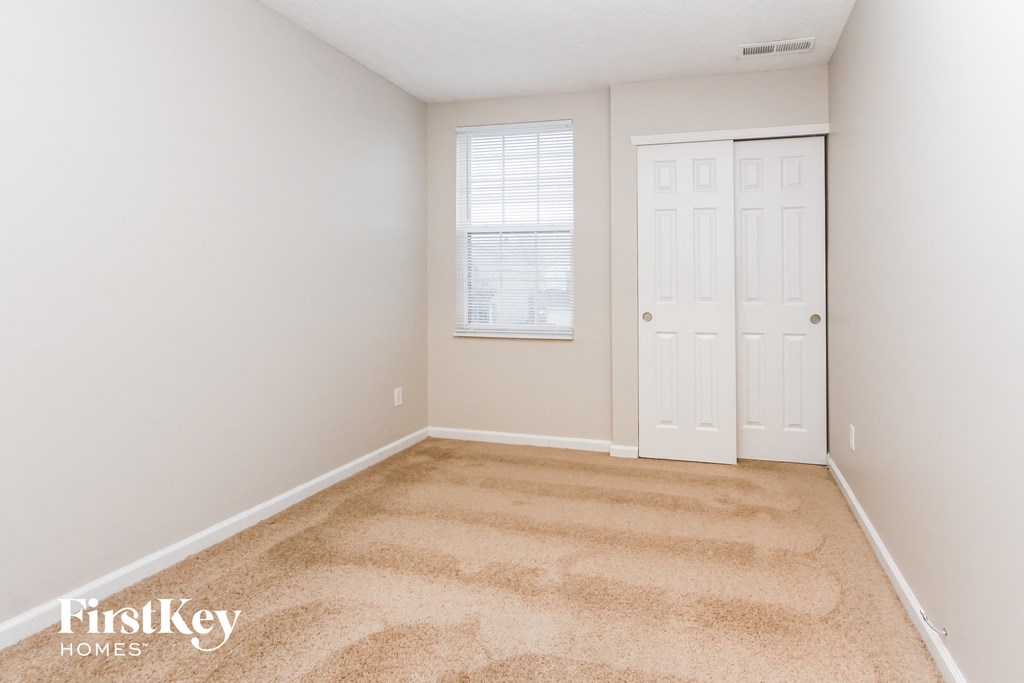 a bedroom with a carpeted floor and a white door
