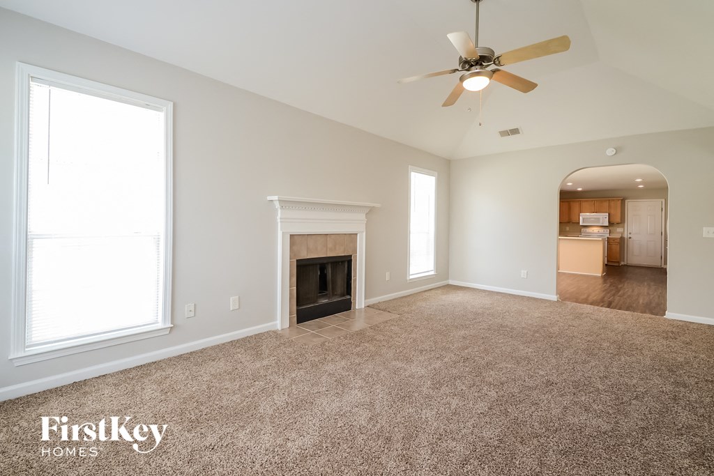 a living room with a fireplace and a ceiling fan
