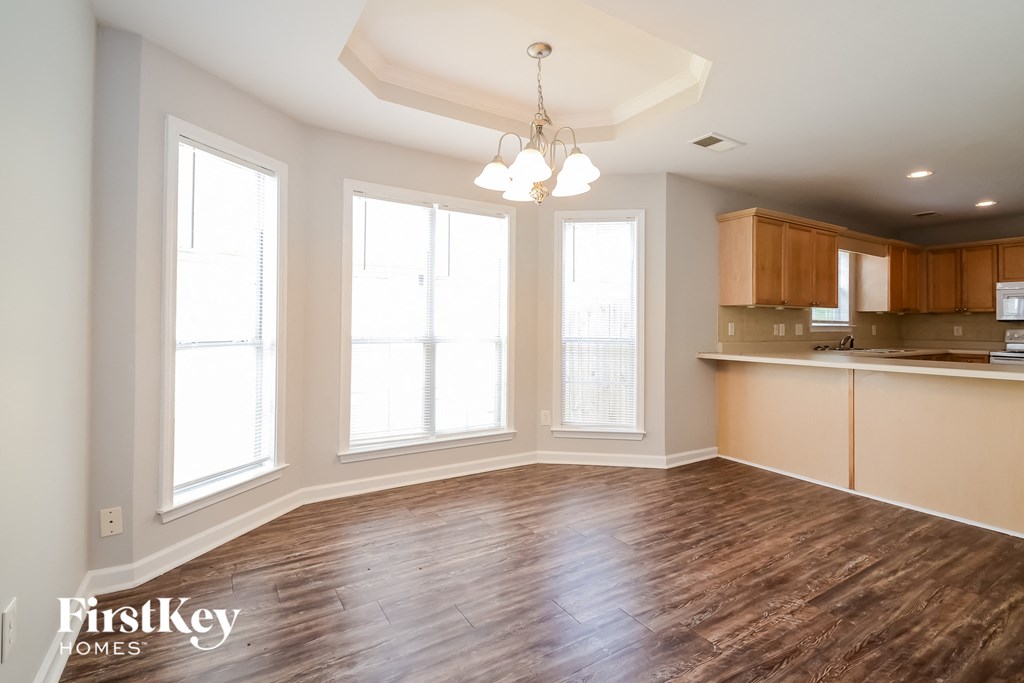 a kitchen and living room with wood flooring in an empty house