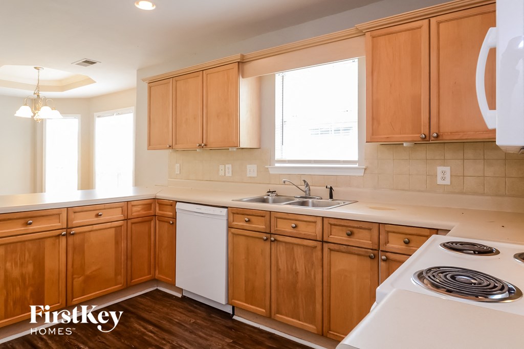 an empty kitchen with wooden cabinets and white appliances