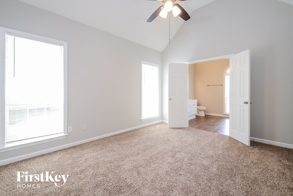a bedroom with a carpeted floor and a ceiling fan