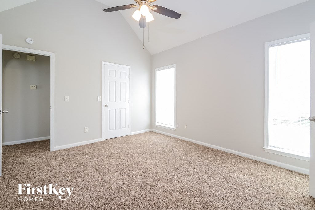 a bedroom with a ceiling fan and a carpeted floor