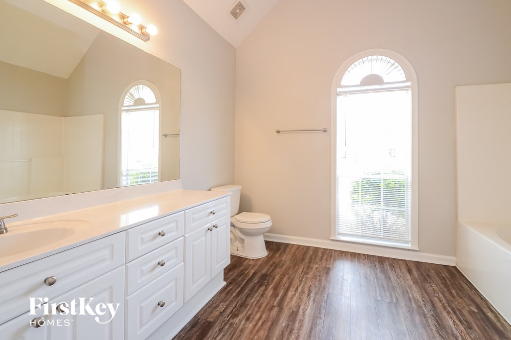 a bathroom with white cabinets and a toilet and a sink