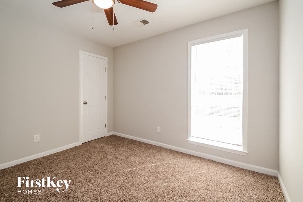 a bedroom with a ceiling fan and a window